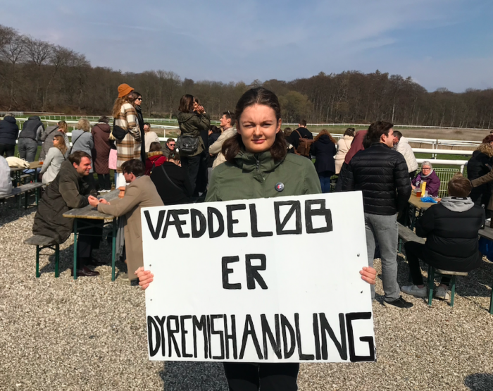 Dyreaktivist med skilte på Klamenborg galopbane